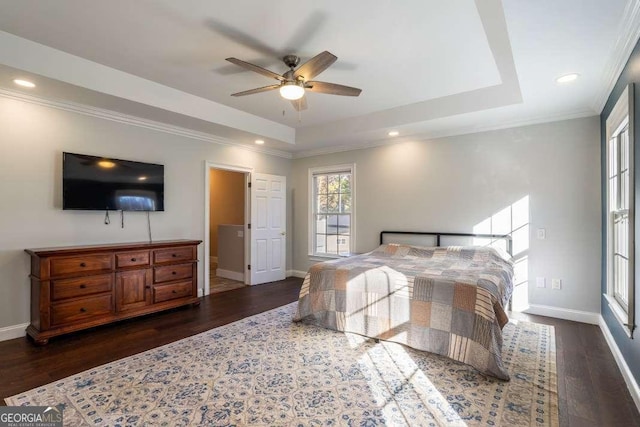 bedroom with a tray ceiling, ornamental molding, baseboards, and wood finished floors