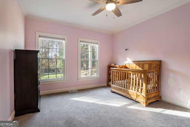 carpeted bedroom featuring crown molding, baseboards, ceiling fan, and visible vents