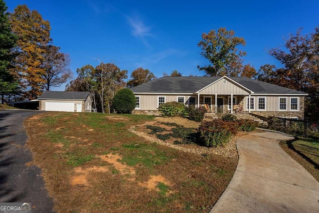 ranch-style house with board and batten siding, driveway, a front lawn, and stone siding