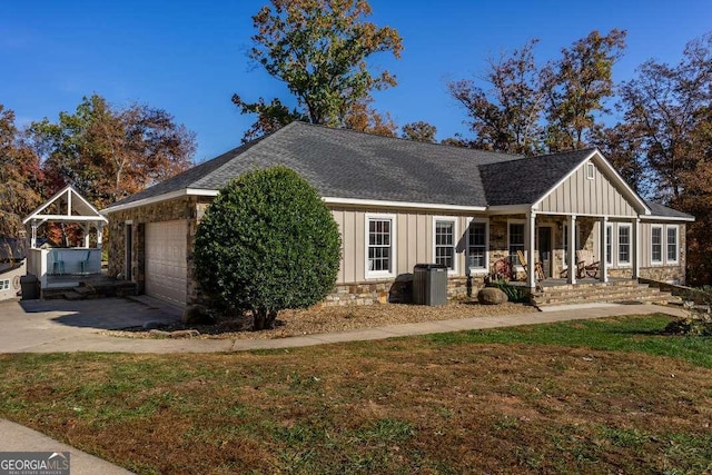 exterior space with covered porch, board and batten siding, driveway, and stone siding