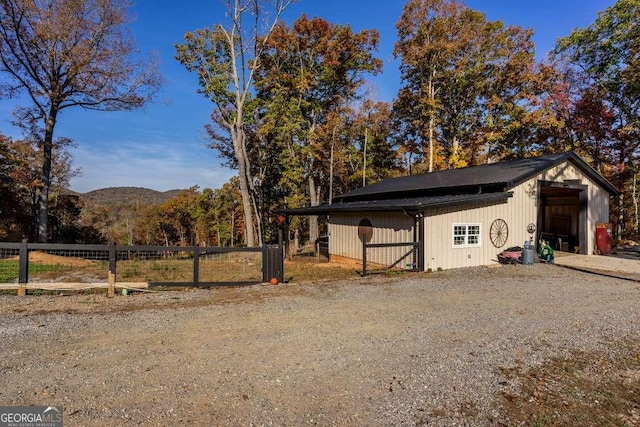 exterior space with fence, a pole building, a mountain view, and an outdoor structure