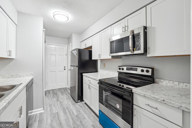 2930 Parc Lorraine, Lithonia, GA 30038 - kitchen with visible vents, light wood-type flooring, white cabinets, a sink, and appliances with stainless steel finishes