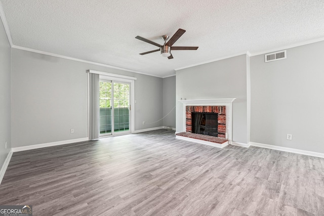 2930 Parc Lorraine, Lithonia, GA 30038 - unfurnished living room with visible vents, ornamental molding, a brick fireplace, a textured ceiling, and ceiling fan with notable chandelier