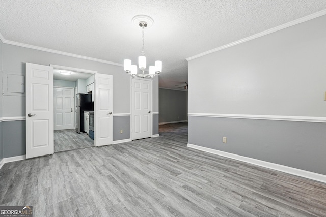 2930 Parc Lorraine, Lithonia, GA 30038 - unfurnished dining area featuring light wood-style floors, a textured ceiling, crown molding, and a notable chandelier