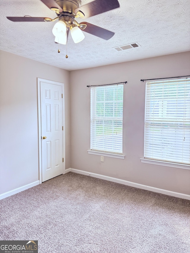 6433 Wellington Chase Ct, Lithonia, GA 30058 - empty room with carpet flooring, ceiling fan, a textured ceiling, baseboards, and visible vents