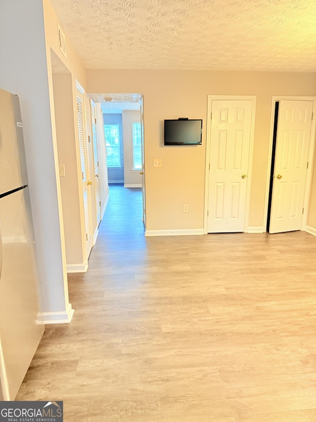 6433 Wellington Chase Ct, Lithonia, GA 30058 - interior space featuring visible vents, a textured ceiling, light wood finished floors, and baseboards