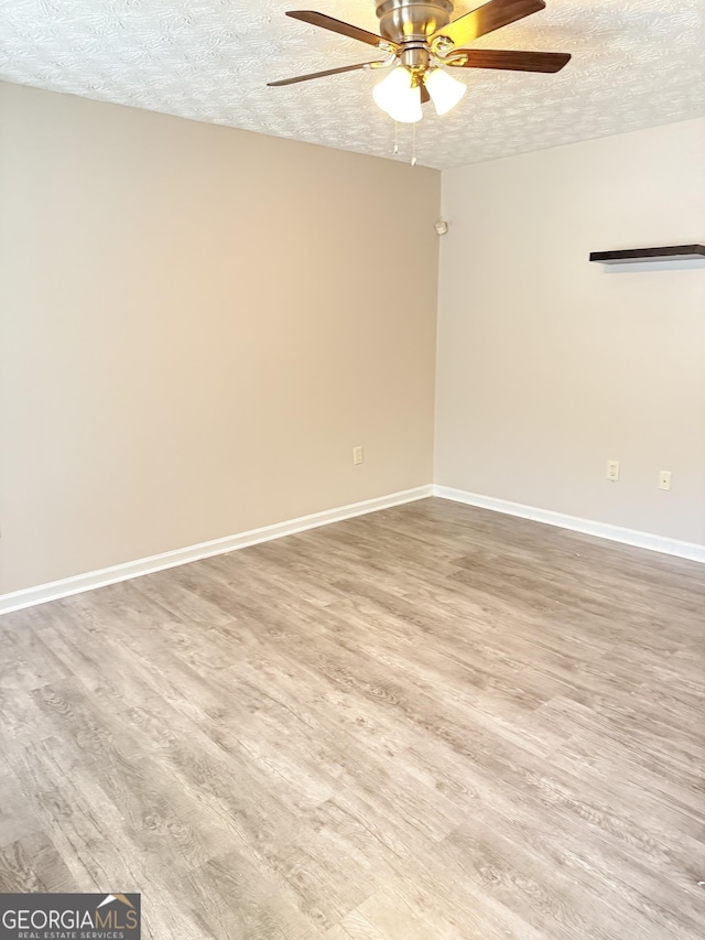 6433 Wellington Chase Ct, Lithonia, GA 30058 - spare room with baseboards, a ceiling fan, a textured ceiling, and wood finished floors