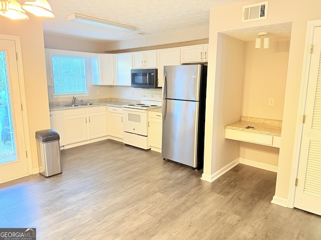 6433 Wellington Chase Ct, Lithonia, GA 30058 - kitchen with electric range, a sink, light wood-style flooring, freestanding refrigerator, and visible vents