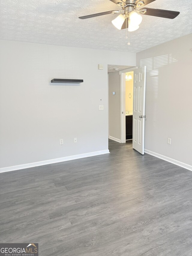 6433 Wellington Chase Ct, Lithonia, GA 30058 - spare room featuring baseboards, ceiling fan, dark wood-style flooring, and a textured ceiling