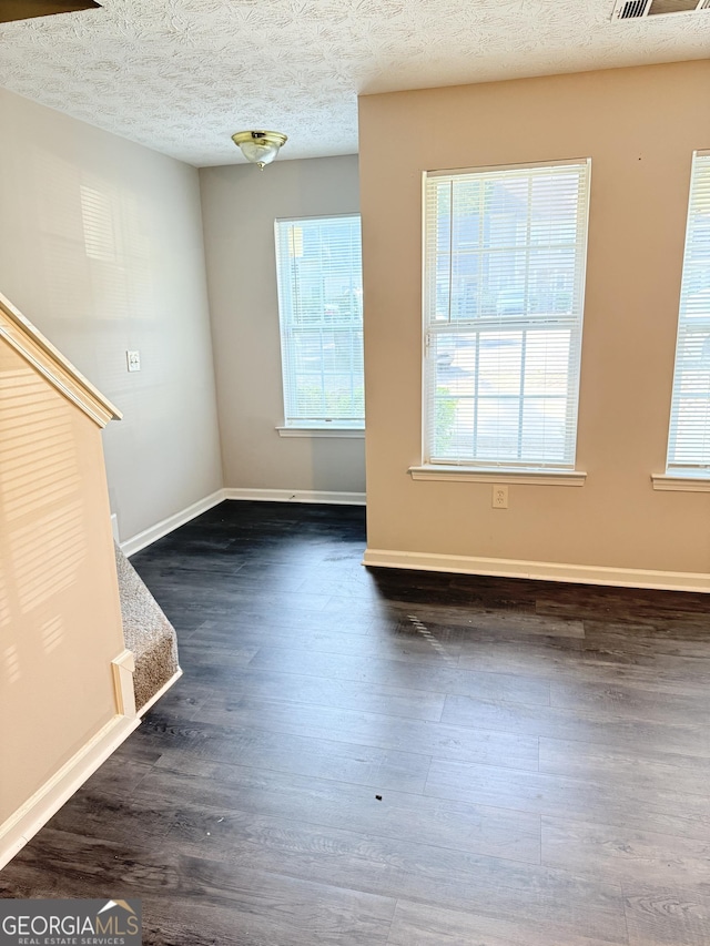 6433 Wellington Chase Ct, Lithonia, GA 30058 - unfurnished living room featuring baseboards, a textured ceiling, and dark wood-style flooring