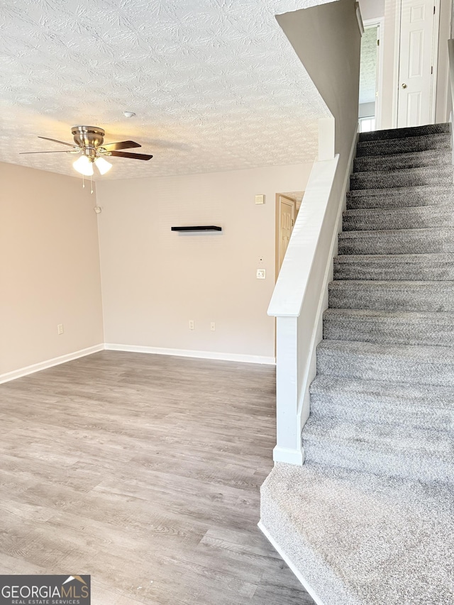 6433 Wellington Chase Ct, Lithonia, GA 30058 - staircase featuring baseboards, a ceiling fan, a textured ceiling, and wood finished floors