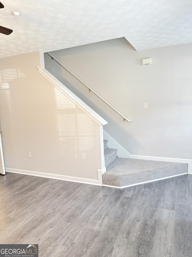 6433 Wellington Chase Ct, Lithonia, GA 30058 - staircase with baseboards, a textured ceiling, ceiling fan, and wood finished floors