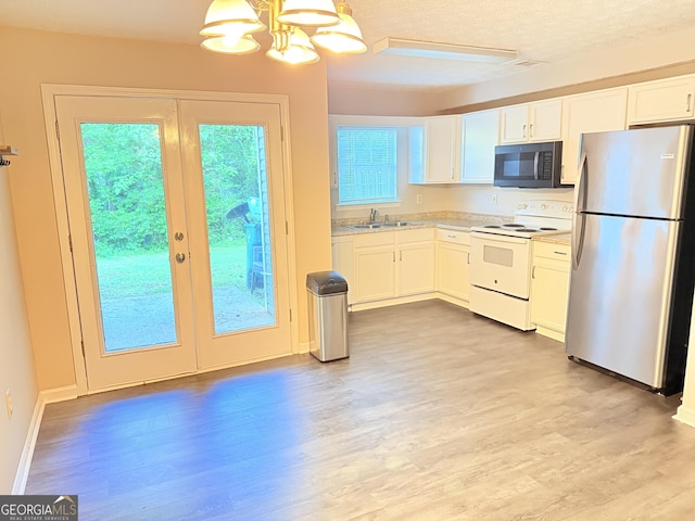 6433 Wellington Chase Ct, Lithonia, GA 30058 - kitchen with white cabinets, black microwave, a notable chandelier, white range with electric cooktop, and freestanding refrigerator