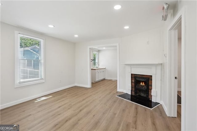 130 S Avenue SE, Marietta, GA 30060 - unfurnished living room with a warm lit fireplace, light wood-style floors, recessed lighting, baseboards, and visible vents