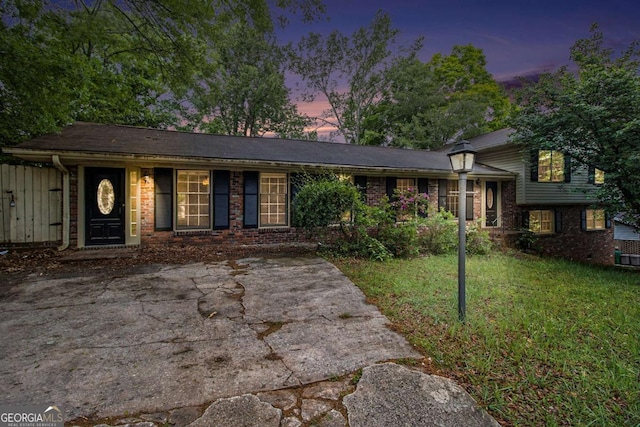 split level home featuring a lawn and brick siding