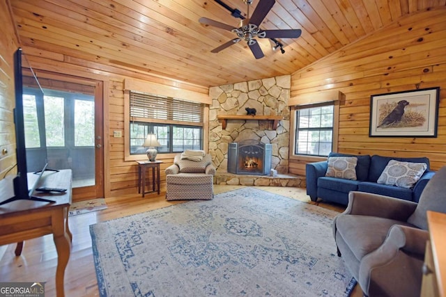 living room featuring wood finished floors, lofted ceiling, a fireplace, ceiling fan, and wooden ceiling