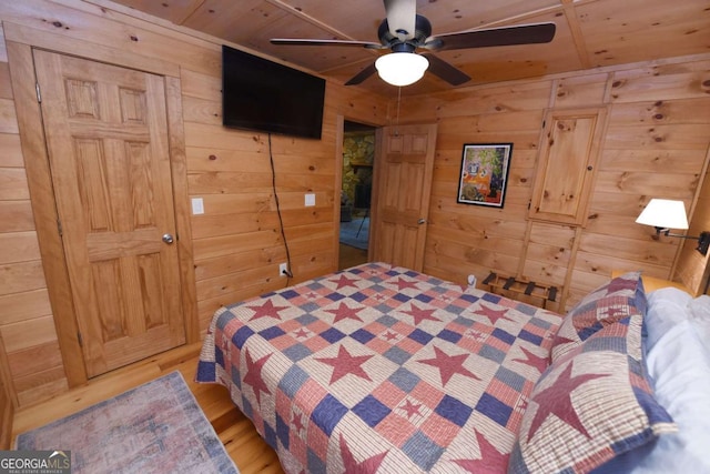 bedroom with light wood finished floors, ceiling fan, wooden walls, and wooden ceiling