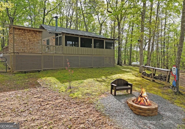 view of yard with a sunroom, an outdoor fire pit, and a deck