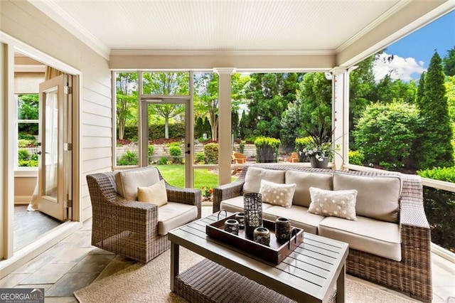 sunroom / solarium featuring stone tile floors, an outdoor living space, and ornamental molding