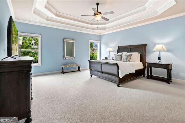 bedroom featuring carpet, a ceiling fan, baseboards, a tray ceiling, and ornamental molding