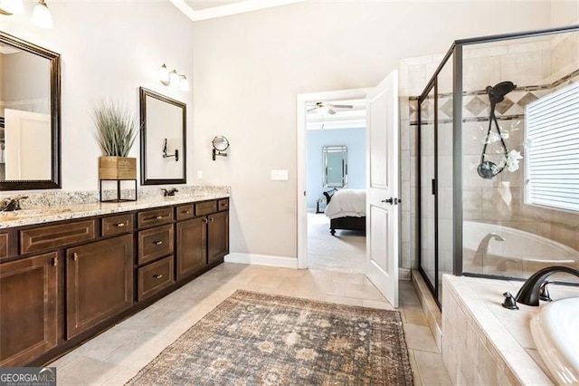 ensuite bathroom featuring double vanity, ceiling fan, a garden tub, and a stall shower