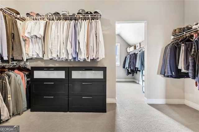 walk in closet featuring carpet flooring and lofted ceiling