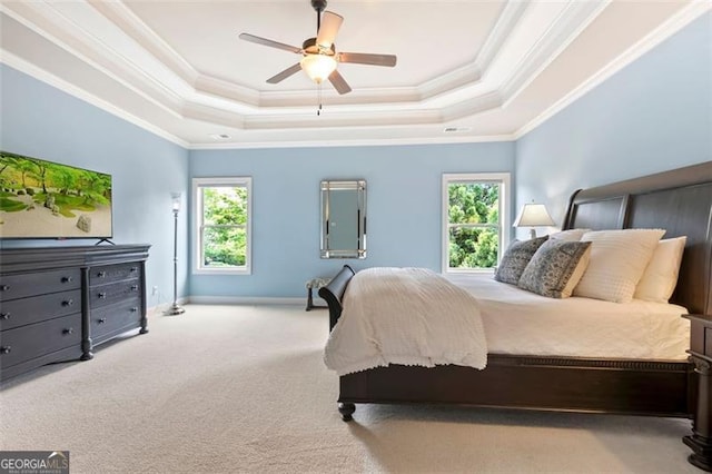 bedroom with a tray ceiling, ornamental molding, baseboards, and carpet