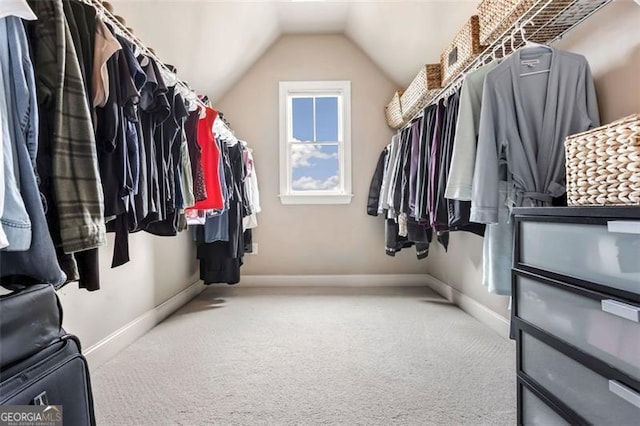 walk in closet with carpet and vaulted ceiling