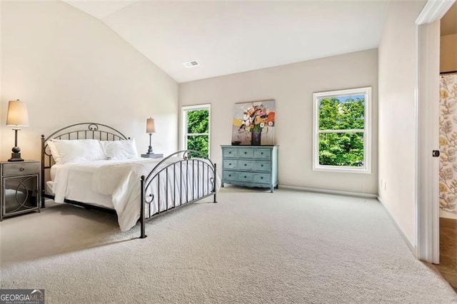 bedroom featuring carpet floors, baseboards, visible vents, and lofted ceiling