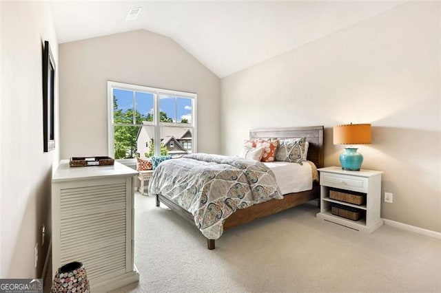bedroom with baseboards, lofted ceiling, and light carpet