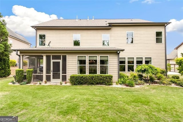 back of property with a sunroom and a yard