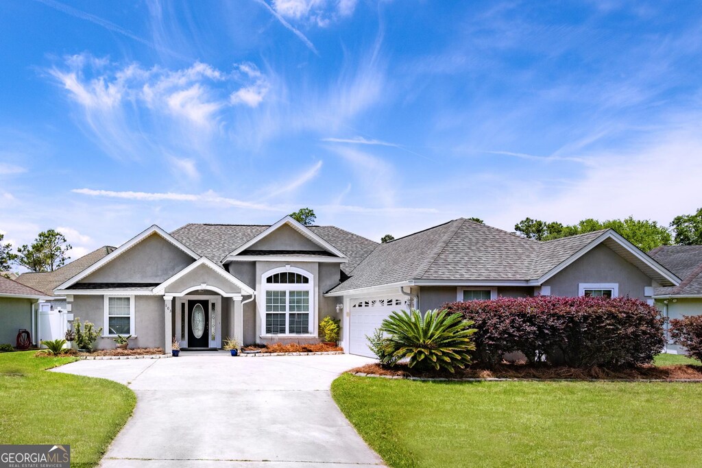 103 Donegal Ln, Kingsland, GA 31548 - single story home featuring a front lawn, stucco siding, a shingled roof, concrete driveway, and an attached garage
