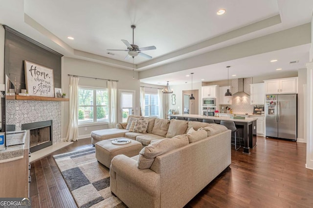 21 E Field St, Newnan, GA 30263 - living room featuring ceiling fan, a tray ceiling, and dark wood-style flooring