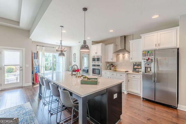21 E Field St, Newnan, GA 30263 - kitchen featuring wall chimney range hood, a kitchen island with sink, stainless steel appliances, and white cabinetry