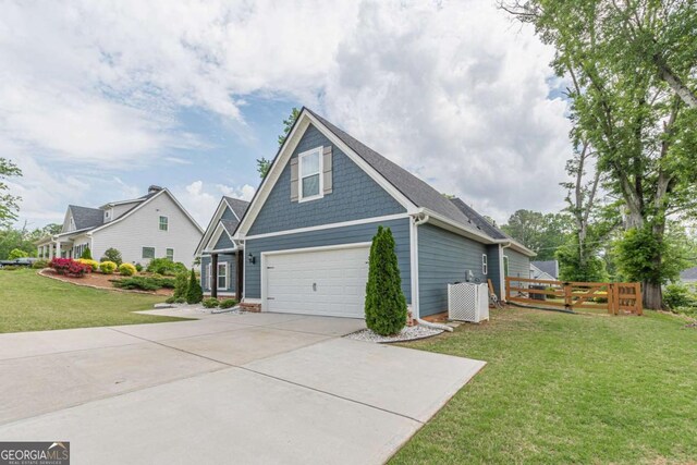 21 E Field St, Newnan, GA 30263 - view of side of home featuring concrete driveway, a yard, fence, and a garage