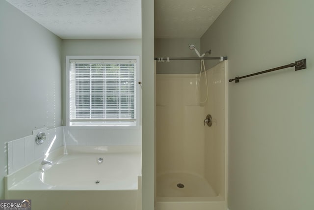 981 Charles Hall Dr, Dacula, GA 30019 - full bathroom featuring a textured ceiling, walk in shower, and a bath