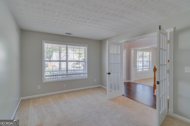981 Charles Hall Dr, Dacula, GA 30019 - carpeted empty room featuring baseboards, french doors, a textured ceiling, and visible vents