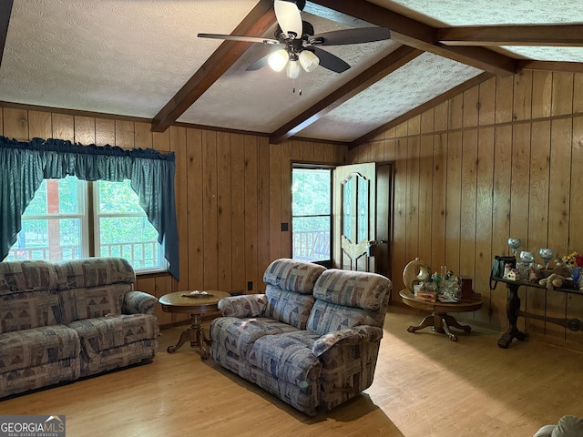 7260 Cox Rd, Cumming, GA 30028 - living room with lofted ceiling with beams, wooden walls, wood finished floors, and a healthy amount of sunlight