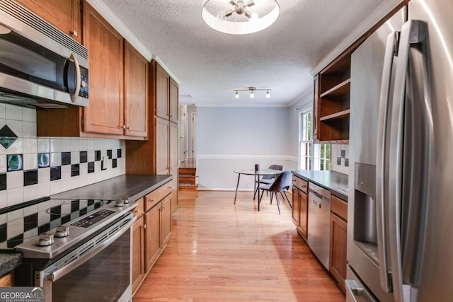 kitchen featuring open shelves, light wood-type flooring, a textured ceiling, tasteful backsplash, and stainless steel appliances
