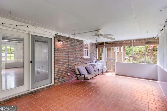 unfurnished sunroom with a ceiling fan