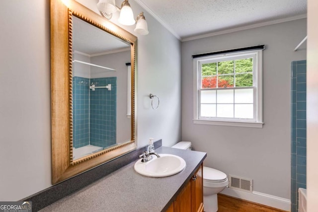 bathroom with vanity, toilet, wood finished floors, visible vents, and ornamental molding