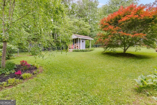 view of yard featuring fence and an outbuilding