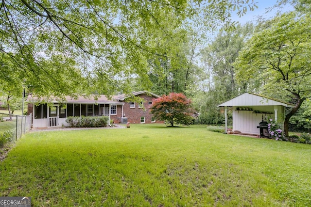 view of yard with fence and a sunroom