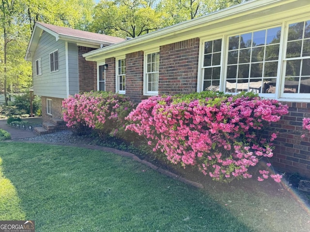 view of home's exterior featuring a yard and brick siding