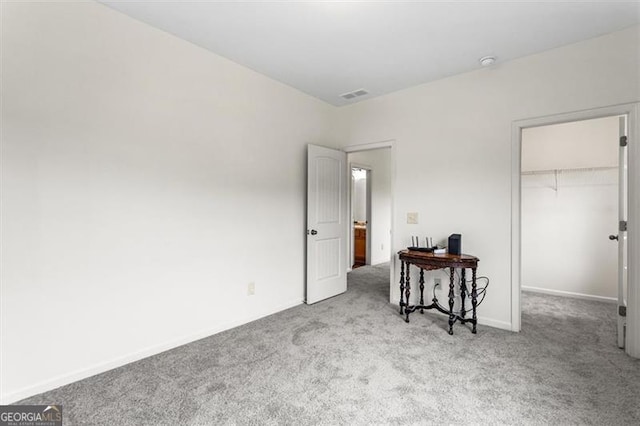 bedroom with visible vents, a closet, baseboards, a spacious closet, and carpet flooring