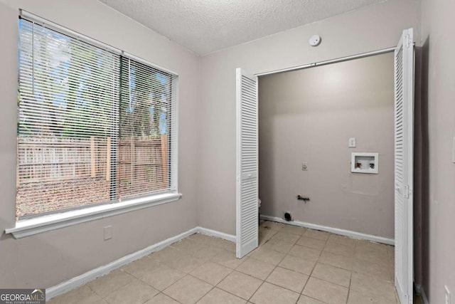 1056 Park W Ct, Stone Mountain, GA 30088 - laundry area with baseboards, hookup for a washing machine, a textured ceiling, and light tile patterned floors