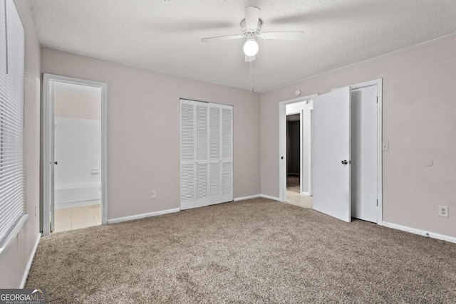 1056 Park W Ct, Stone Mountain, GA 30088 - unfurnished bedroom featuring carpet floors, ensuite bathroom, baseboards, and a ceiling fan