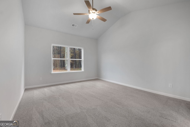 carpeted spare room featuring visible vents, baseboards, ceiling fan, and lofted ceiling