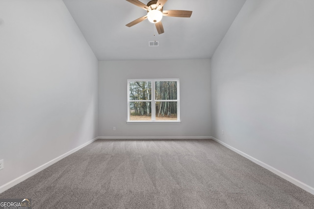carpeted spare room with vaulted ceiling, baseboards, a ceiling fan, and visible vents