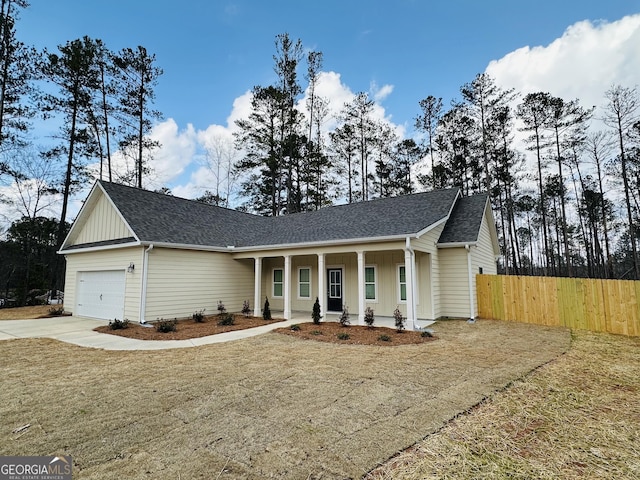 view of front of home featuring fence, covered porch, board and batten siding, and concrete driveway